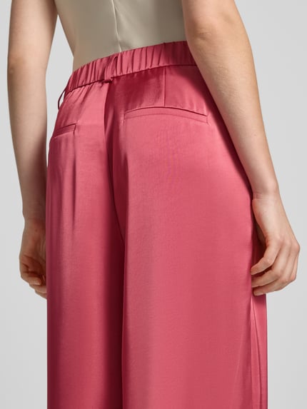 Frauenmodel trägt Satinhose mit angedeuteten Gesäßleistentaschen Modell 'Emmett' von Neo Noir, Satin, Wide-Leg-Fit, Detailaufnahme Rückansicht