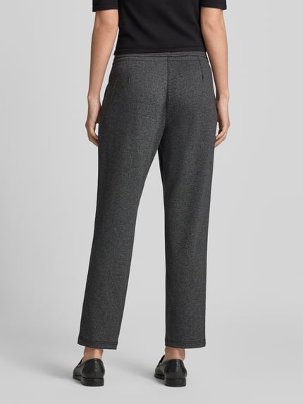 Frauenmodel trägt Jogpants in Two-Tone-Machart mit Tunnelzug von Christian Berg Woman, Material-Mix mit Viskose-Anteil, Regular Fit, ganzkörperansicht Rückansicht.