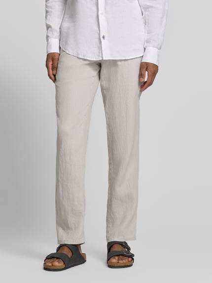 Męski model nosi Straight Fit Leinenhose aus reinen Leinen Modell 'Lynx' von Mmx, kolor jasny beż, struktura lniana, kieszenie z tyłu, zapięcie na guzik i zamek błyskawiczny, szerokość w rozmiarze 32/32: 43 cm, długość wewnętrzna nogawki: 81 cm, widok z przodu, zdjęcie całej sylwetki.