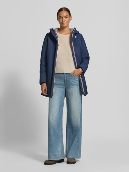 Frauenmodel trägt Regular Fit Mantel mit Logo-Applikation Modell 'SOPHIE' von K-WAY in Dunkelblau mit Kapuze, Ganzkörperansicht von vorne. Damen Mantel, Rückenlänge 73 cm, Schulterbreite 41 cm, Brustweite 46 cm, Ärmellänge 53 cm.