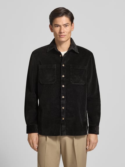 Männermodel trägt Regular Fit Hemdjacke aus Cord mit Kentkragen von Christian Berg Men, schwarze Farbe, Brusttaschen, Ganzkörperansicht von vorne.
