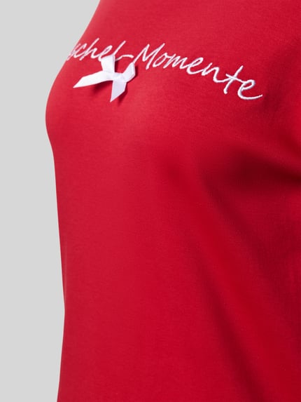 Frauenmodel trägt Nachthemd mit Statement-Stitching Modell 'Kuschel-Momente' von LOUIS & LOUISA in Rot, reine Baumwolle, Detailaufnahme.