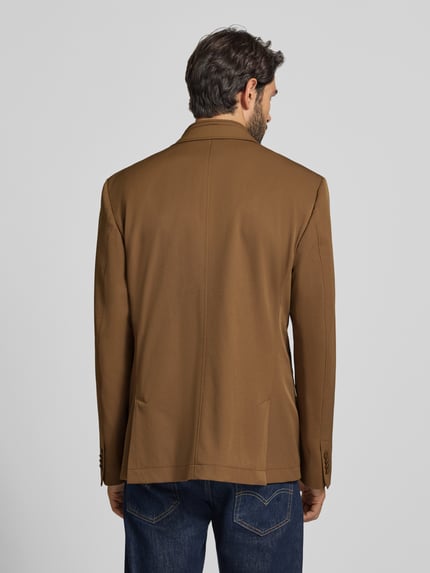 Männermodel trägt Slim Fit 2-in-1-Sakko mit Pattentaschen von bugatti in Braun, Material-Mix mit Stretch, Rückenansicht, Ganzkörperansicht Rückansicht.