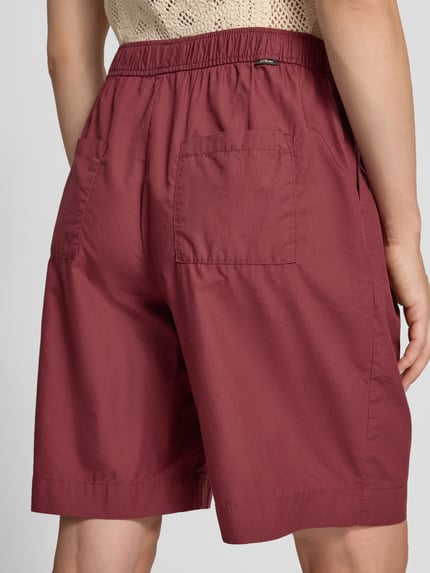 Kobiece modelka ma na sobie Relaxed Fit Bermuda aus reiner Baumwolle od s.Oliver RED LABEL, kolor bordowy, gładka faktura, widok całej sylwetki z tyłu