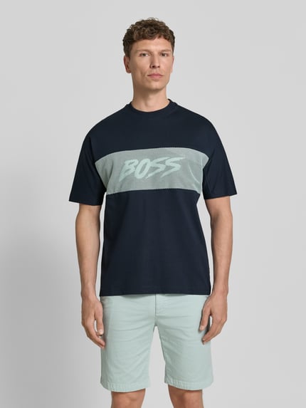 Mężczyzna model nosi Regular Fit T-Shirt aus reiner Baumwolle Modell 'TE_BAYMESH' von BOSS Orange, kolor jednolity, aplikacja z logo, elementy mesh, okrągły dekolt, krótki rękaw, jersey, bawełna, Ganzkörperansicht von vorne.