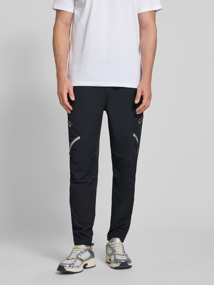 Männermodel trägt schwarze Regular Fit Sweatpants mit Logo-Print Modell 'Unstoppable' von Under Armour, Cargo-Taschen, Elastischer-Material-Mix, Herren, Ganzkörperansicht von vorne.