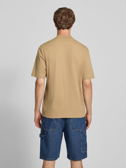 Mężczyznamodel trägt męski t-shirt Regular Fit T-Shirt aus reiner Baumwolle Modell 'NIEROS' von HUGO w beżowym kolorze, gładka faktura, Ganzkörperansicht Rückansicht.