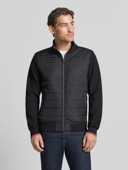 Männermodel trägt Steppjacke aus Baumwoll-Mix von Christian Berg Men, Dopasowany krój, Mieszanka bawełny i elastanu, Stójka, Rękawy z dzianiny dresowej, zamek błyskawiczny, wpuszczane kieszenie, prążkowane wykończenia, długość tyłu w rozmiarze M: 67 cm, długość rękawów w rozmiarze M: 66 cm, całkowity widok z przodu.