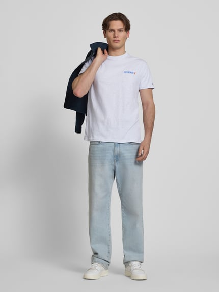 Männermodel trägt Regular Fit T-Shirt aus reiner Baumwolle von Tommy Jeans, Optik: Unifarben, Passform: Regular-Fit, Label-Print, Rundhals, Ärmelform: Kurzarm, Materialverarbeitung: Jersey, Material: reine Baumwolle, Ganzkörperansicht von vorne.