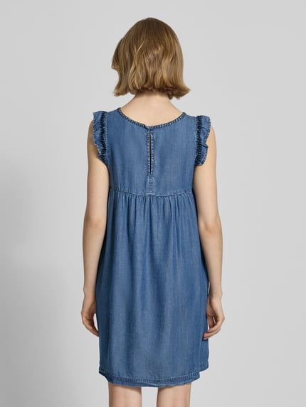Vrouwenmodel draagt Tailliertes Jeanskleid aus Lyocell Modell 'CINDY' van Pepe Jeans in blauwe denimlook met motiefstiksel, mini-lengte, recht zoom, korte kapmouw, zijzakken, ronde hals en knoopsluiting, detailopname van achteraan.