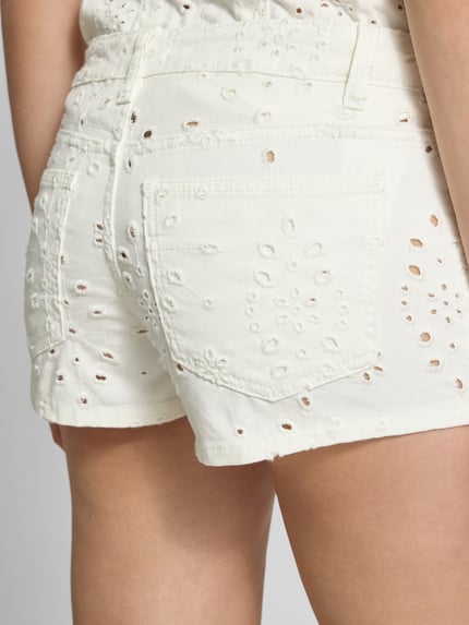 Frauenmodel trägt Straight Fit Shorts mit floralem Loch-Stitching von Gina Tricot aus Reine Baumwolle, 5-Pocket-Design, Nahaufnahme Rückansicht.