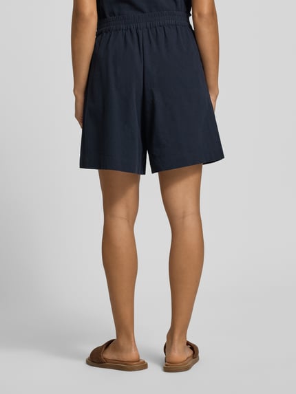 Frauenmodel trägt Regular Fit Bermudas mit elastischem Bund Modell 'CISSIE' von Soyaconcept in Dunkelblau, reine Baumwolle, Ganzkörperansicht Rückansicht.