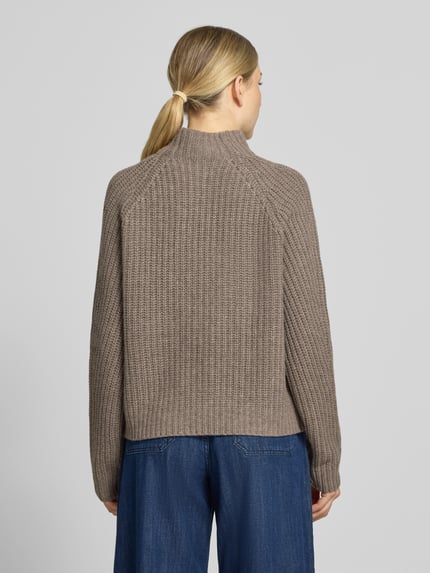 Frauenmodel trägt Strickpullover aus Kaschmir-Baumwoll-Mix Modell 'LONA' von 0039 Italy in Taupe, strukturierte Oberfläche, Ganzkörperansicht Rückansicht. Regular Fit mit Stehkragen, Rückenlänge 60 cm, Ärmellänge 78 cm bei Größe 36.
