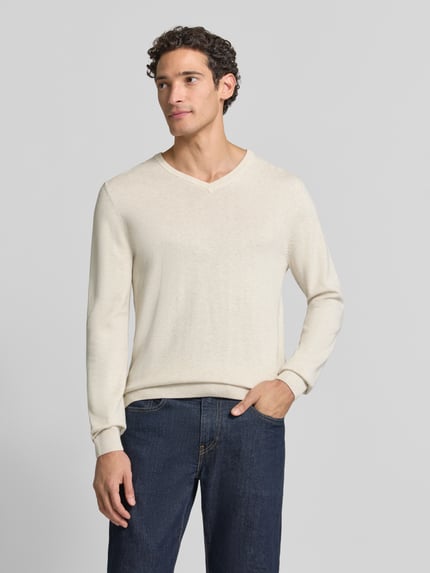 Männermodel trägt Pullover mit Logo-Detail von S.OLIVER CASUAL, unifarben, Feinstrick, V-Ausschnitt, gerippte Abschlüsse, Ganzkörperansicht von vorne.