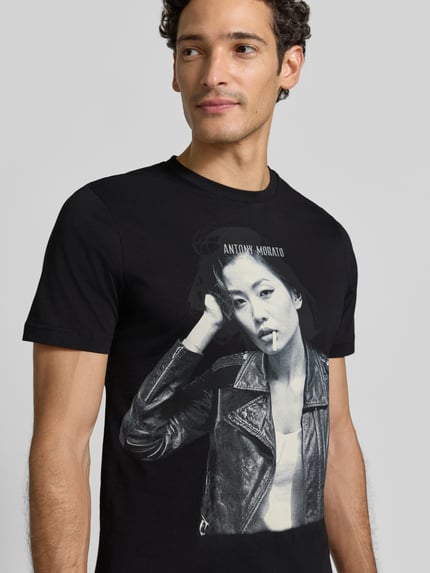 Männermodel trägt schwarzes Regular Fit T-Shirt aus reiner Escorial-Wolle von Antony Morato mit Label-Print, Nahaufnahme Oberkörper.