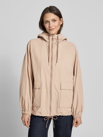 Frauenmodel trägt Jacke mit Kapuze und Pattentaschen von Jake*s Casual in Relaxed-Fit, beige, Reißverschluss, Ganzkörperansicht von vorne, Rückenlänge bei Größe 36: 66 cm, Schulterbreite: 41 cm, Brustweite: 56 cm, Ärmellänge: 65 cm.