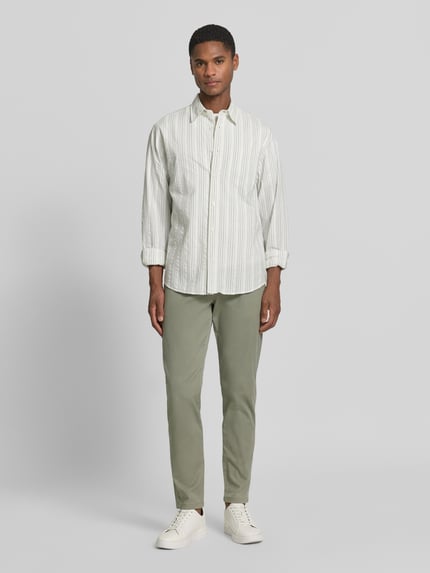 Männermodel trägt Slim Fit chino uit katoenmix model 'MILES' van Selected Homme, look: effen, zij-steekzakken, knoop- en ritssluiting, katoentextuur, Ganzkörperansicht van voren.