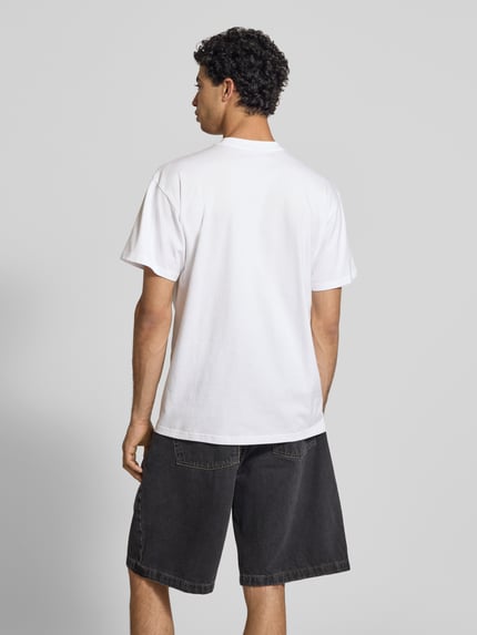 Mannelijk model draagt T-Shirt mit Brusttasche und Label-Patch van Carhartt Work In Progress in wit, katoen, modern fit, rugaanzicht, ruglengte maat M 73 cm.