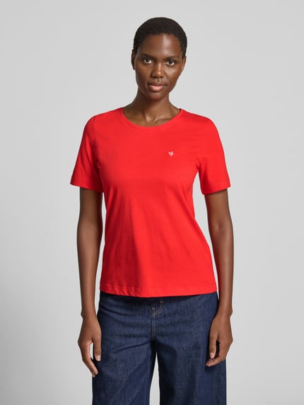 Modelka kobieca nosi T-Shirt mit Motiv-Stitching und Rundhalsausschnitt von Christian Berg Woman, czysta bawełna, krój regular fit, czerwony kolor, z widocznym przeszyciem, długość tyłu w rozmiarze S: 59 cm, ujęcie całej sylwetki z przodu.