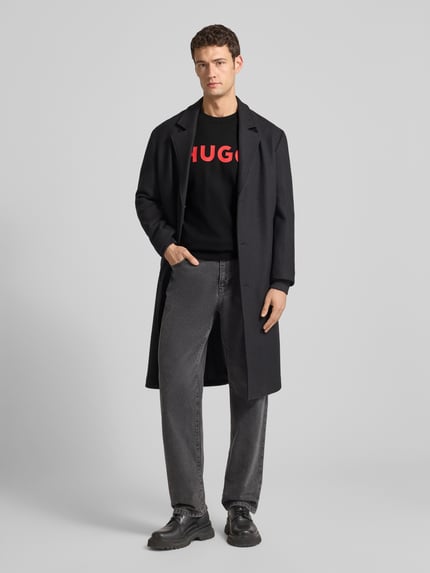 Männermodel trägt Herren Sweatshirt mit Label-Detail Modell 'Dem' von HUGO, reine Baumwolle, lockere Passform, Ganzkörperansicht von vorne.