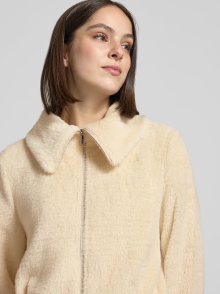 Vrouwenmodel draagt Regular Fit Blazer aus Kunstfell van zero in lichtbeige, zachte textuur, omlegekraag, zichtbare rits, Nahaufnahme bovenlichaam.