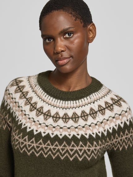 Frauenmodel trägt Pullover mit kontrastreichem Rundhals-Jacquard von VERO MODA in mehrfarbiger Jacquard-Strickoptik, Nahaufnahme Oberkörper.