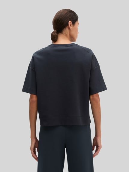 Frauenmodell trägt Loose Fit T-Shirt aus Baumwoll-Mix von Marc O'Polo in dunklem Blau, glatte Textur, Ganzkörperansicht Rückansicht, Damen T-Shirt von Marc O'Polo