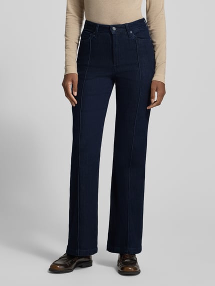 Frauenmodel trägt Regular Fit Bootcut Jeans mit Teilungsnähten von S.OLIVER CASUAL in dunkelblauem Denim mit 5-Pocket-Design, Ganzkörperansicht von vorne.