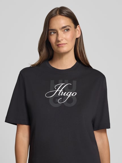 Kobieta prezentuje damski t-shirt Regular Fit T-Shirt aus reiner Baumwolle Modell 'Dashire_5' von HUGO w kolorze czarnym, nadruk z logo, damski t-shirt od HUGO, zbliżenie na górną część ciała