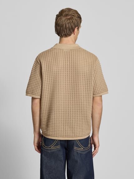 Męski model nosi Regular Fit Poloshirt mit V-Ausschnitt von Jack & Jones z czystej bawełny, dzianina, beżowy kolor, krój regular fit, widok całej sylwetki z tyłu.