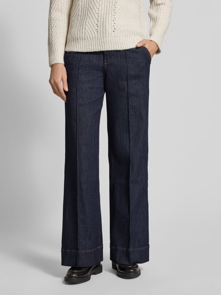 Vrouwenmodel draagt Wide Leg Jeans uit katoenmix van s.Oliver RED LABEL, glanzende look, high waist, labelpatch, 5-pocketmodel, denim, katoenmix. Detailopname onderlichaam.