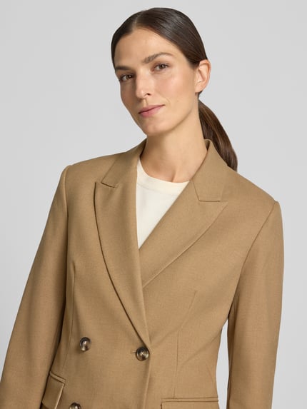 Frauenmodel trägt Regular Fit Kurzblazer mit Viskose-Anteil von Jake*s Collection in Hellbraun mit Knöpfen, Nahaufnahme Oberkörper.