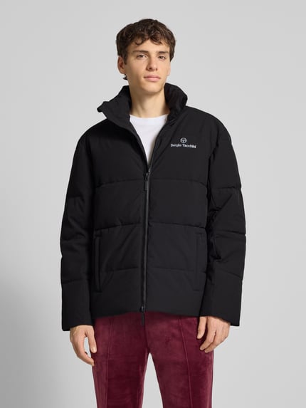 Männermodel trägt schwarze Steppjacke mit Stehkragen Modell 'NILO' von SERGIO TACCHINI, Material-Mix mit Stretch-Anteil, Regular Fit, Nahaufnahme Oberkörper.