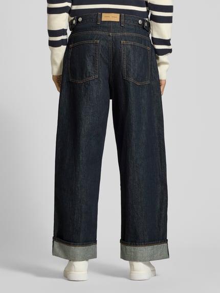 Männermodel trägt Wide Fit Jeans aus reiner Baumwolle Modell 'TIMOTHY' von Samsøe Samsøe, dunkles Denim, 5-Pocket, Ganzkörperansicht Rückansicht. Herren Jeans von Samsøe Samsøe, reine Baumwolle, Wide Fit, Gürtelschlaufen, Knopf- und Reißverschluss, Bundweite 43 cm, Innenbeinlänge 72 cm.
