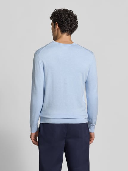 Männermodel trägt Strickpullover mit geripptem Rundhalsausschnitt von MCNEAL in Hellblau, glatte Textur, Ganzkörperansicht Rückansicht. Taillierte Passform, gerippte Abschlüsse, leicht überschnittene Schultern, Rückenlänge bei Größe M: 70 cm, Ärmellänge: 65 cm.