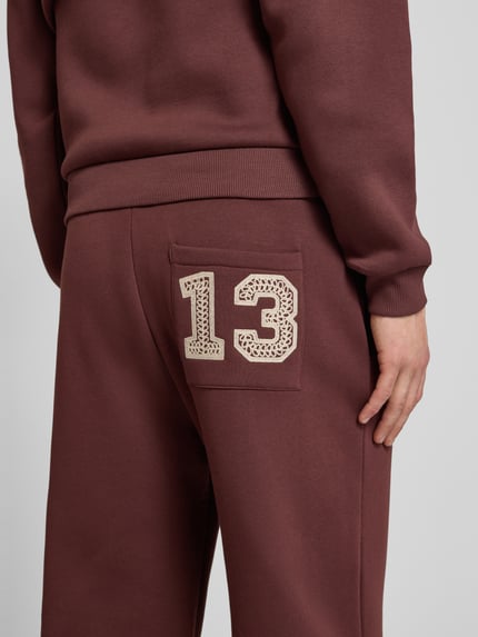 Männermodel trägt Sweatpants mit elastischem Bund und Gesäßtasche von REVIEW, Baumwoll-Mix, Relaxed-Fit, Detailaufnahme Gesäßtasche.