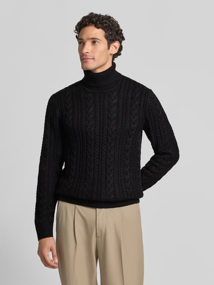Męski model nosi Slim Fit sweter z dzianiny z mieszanką bawełny Model 'Callum' od JACK & JONES, ścieg warkoczowy, czarny, prążkowany golf, prążkowane wykończenia, całkowita długość pleców 73 cm, długość rękawów 74 cm, krój z długim rękawem, widok całej sylwetki z przodu.