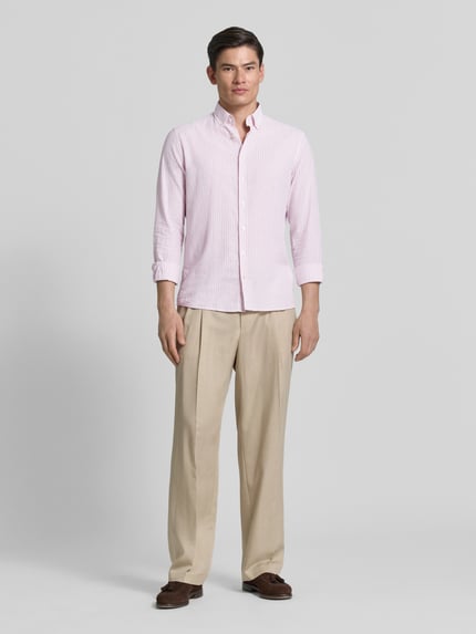 Männermodel trägt Slim Fit Freizeithemd aus Baumwoll-Leinen-Mix Modell 'Stone' von CINQUE in Hellrosa, Langärmelig, Button-Down-Kragen, durchgehende Knopfleiste, glatte Struktur, Rückenlänge 67 cm, Schulterbreite 43 cm, Ärmellänge 66 cm, Ganzkörperansicht von vorne.