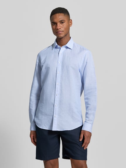 Männermodel trägt Slim Fit Business-Hemd aus Leinen-Mix von Jake*s in lichtblauw met lange mouwen, kentkraag en knoopsluiting, ganzkörperansicht von vorne. Context: heren zakelijk hemd van Jake*s, mix van katoen en linnen, slim fit, kentkraag, knoopsluiting, met lange mouwen, ruglengte maat M: 69 cm, schouderbreedte maat M: 46 cm, mouwlengte maat M: 64 cm.