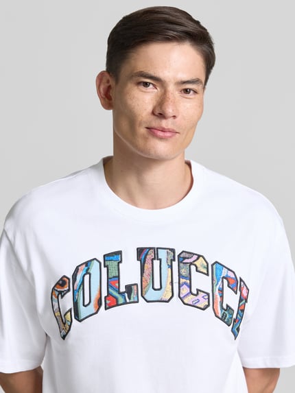 Mannelijk model draagt T-Shirt met 1/2-Arm van COLUCCI, wit met kleurrijke letters, rechte fit, ronde hals, puur katoen, detailopname bovenlichaam.