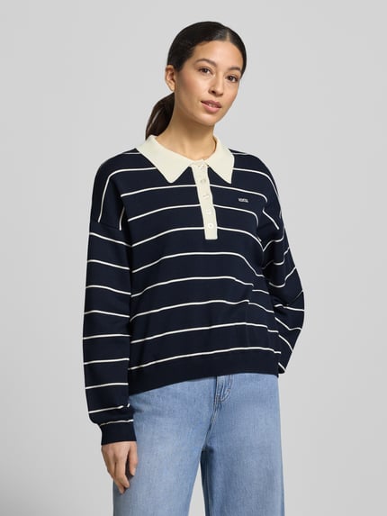 Frauenmodel trägt Gestuz Strickpullover mit Polokragen Modell 'taige' im Oversized-Look, dunkelblau mit weißen Streifen, Nahaufnahme Oberkörper.