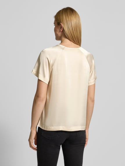 Frauenmodel trägt Relaxed Fit Bluse mit gelegten Falten von Comma, Satin, Elastischer-Material-Mix, Kurzarm, Rundhalsausschnitt, Rückenlänge 60 cm, Rückansicht.