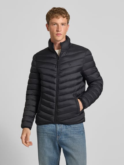 Männermodel trägt Regular Fit Steppjacke mit Logo-Stickerei von REVIEW in Schwarz mit Stepp-Optik, Ganzkörperansicht von vorne.