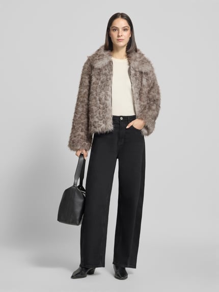Frauenmodel trägt Webpelzjacke mit Umlegekragen von VERO MODA, melange Optik, Strukturmuster, cropped Länge, langarm, Ganzkörperansicht von vorne.