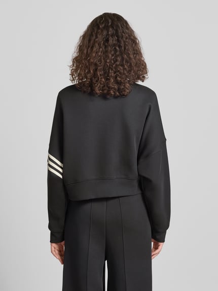 Frauenmodel trägt Regular Fit Sweatjacke aus Baumwoll-Mix von adidas Originals, Optik: Unifarben, Ganzkörperansicht Rückansicht.