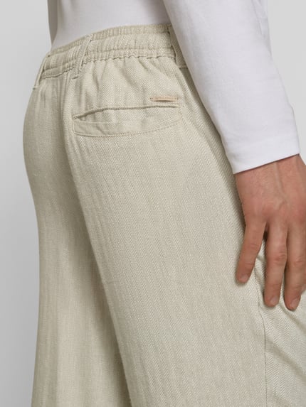 Mannenmodel draagt Leinenhose mit Bindegürtel Modell 'KARL MYKONOS' van Jack & Jones, mix van linnen en viscose, relaxed fit, strookzak aan de achterkant, detailopname.