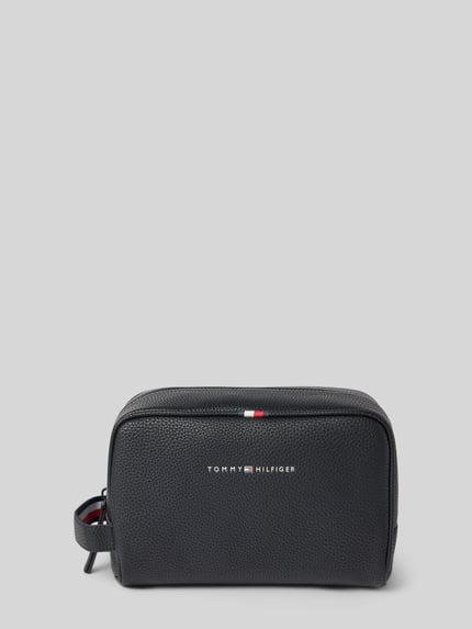 Produktfoto, Kulturbeutel mit Label-Details von Tommy Hilfiger, schwarzes strukturiertes Material, Hauptfach mit Reißverschluss, kurzer Henkel, Reißverschlussfach und Steckfächer innen, 24 cm Breite, 15 cm Länge, 11 cm Tiefe, moderner Look