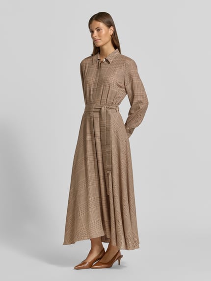 Modelka prezentuje sukienkę koszulową z mieszanki wiskozy z dodatkiem żywej wełny Marella Hemdblusenkleid aus Viskose-Mix Modell 'Utile', taliowany krój, kołnierzyk koszulowy, długi rękaw, listwa guzikowa, długość tyłu w rozmiarze 36: 122 cm, szerokość w rozmiarze 36: 47 cm, długość rękawów w rozmiarze 36: 60 cm, wzór w kratkę, odcień beżowo-brązowy, gładka faktura, widok całej sylwetki z przodu.