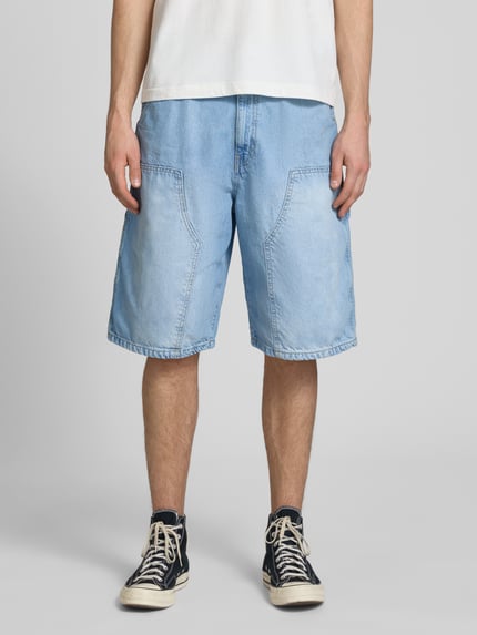 Männermodel trägt Regular Fit Jeansshorts mit Label-Details von REVIEW, hellblauer Denim, 5-Pocket-Design, Ganzkörperansicht von vorne.