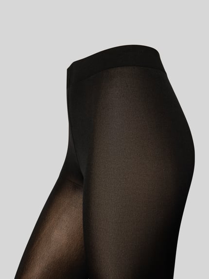 Frauenmodel trägt Strumpfhose mit elastischem Bund von Falke, körpernaher Schnitt, semitransparenter Look, Nahaufnahme Hüfte.